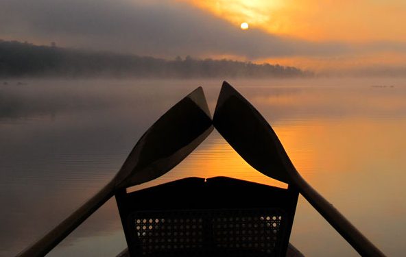 Misty lake sunset over Guide boat oars